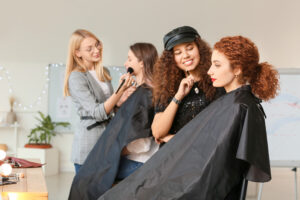 Young woman applying makeup to the model