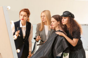 Young woman teaching students how to apply makeup to the model